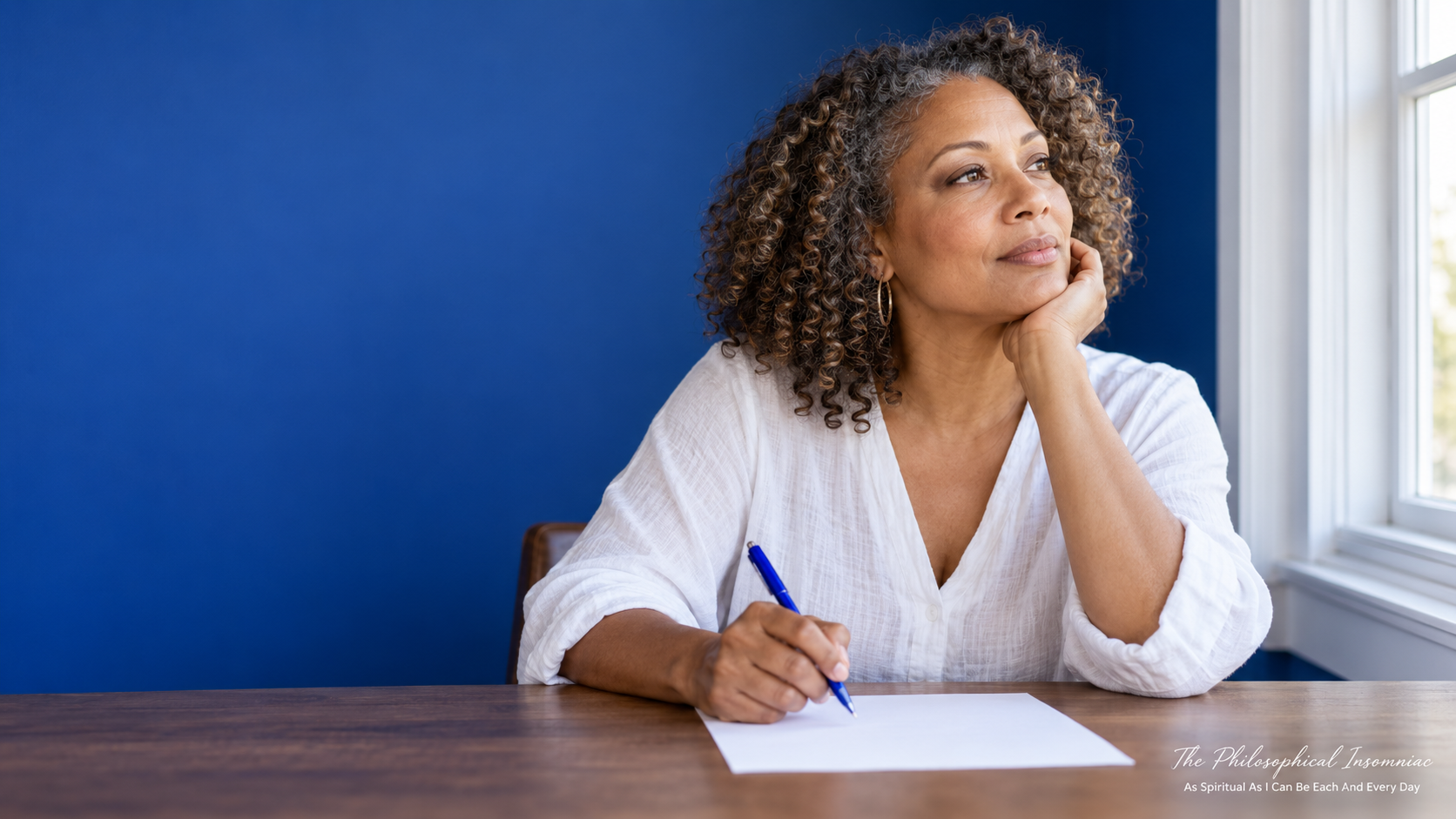A light-skinned Black woman pausing in thought while writing